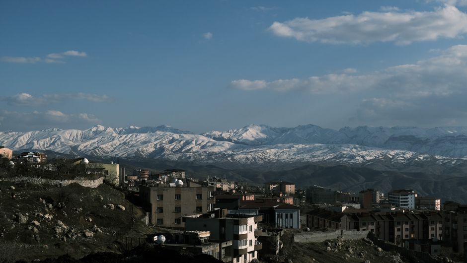 Urban landscape with snow-capped mountains, showcasing a serene city view.