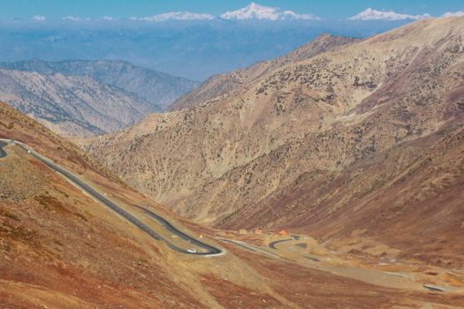 Breathtaking view of a winding road traversing the arid mountains in Kaghan Valley, Pakistan.