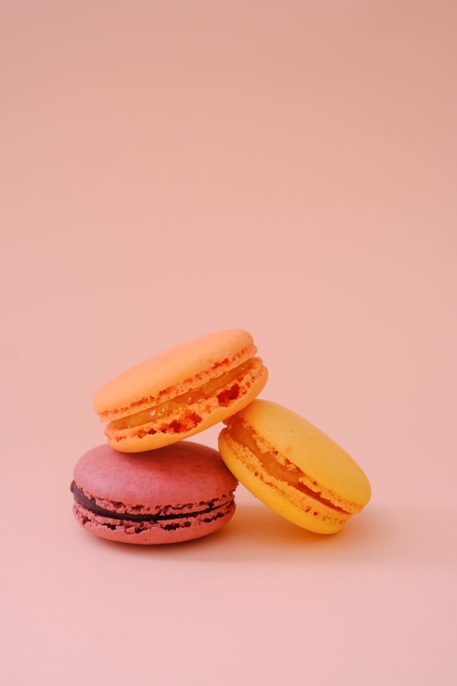 Delicate pink macarons stacked on a blush background