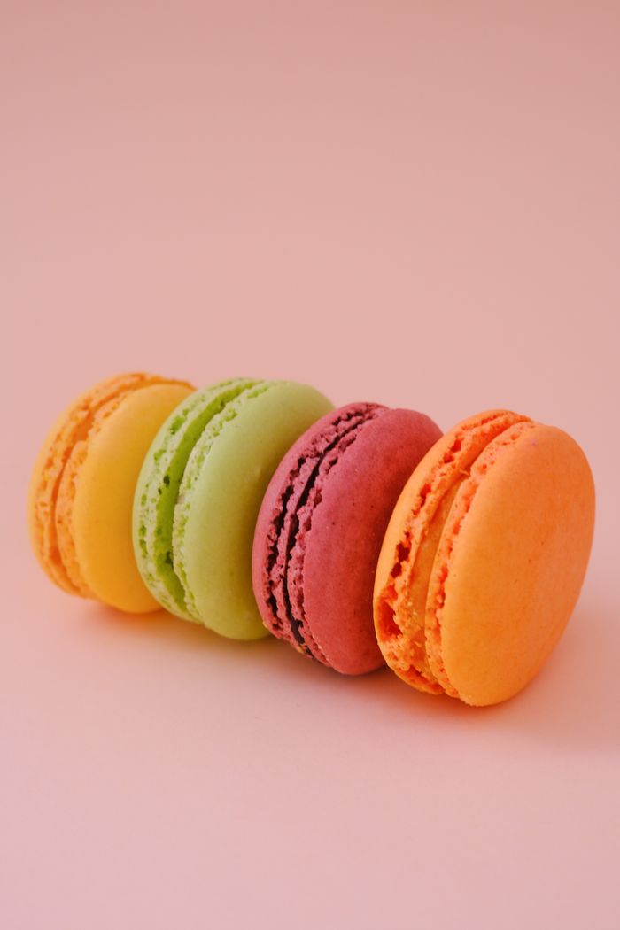Colourful pastel macarons arranged on a pink background