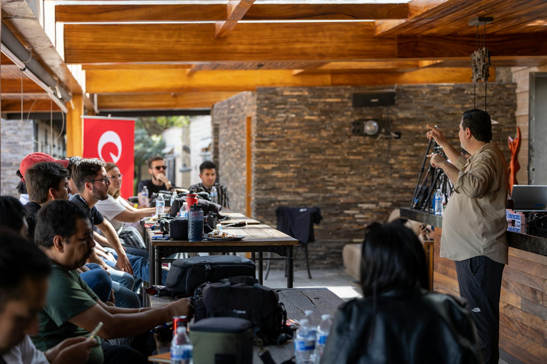 A diverse team gathered for an engaging meeting in a rustic outdoor setting.