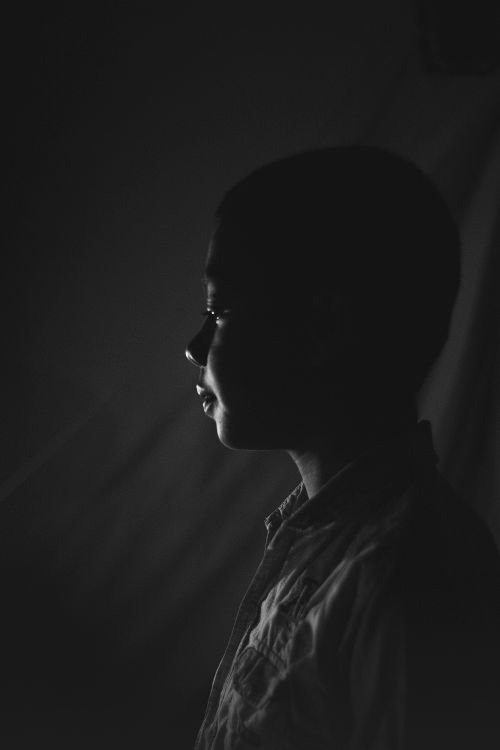 Free A moody black and white profile portrait of a young boy, evoking emotions and depth. Stock Photo