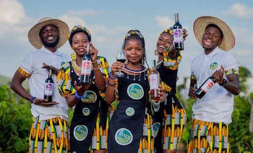 Smiling People Holding Bottles of Wine