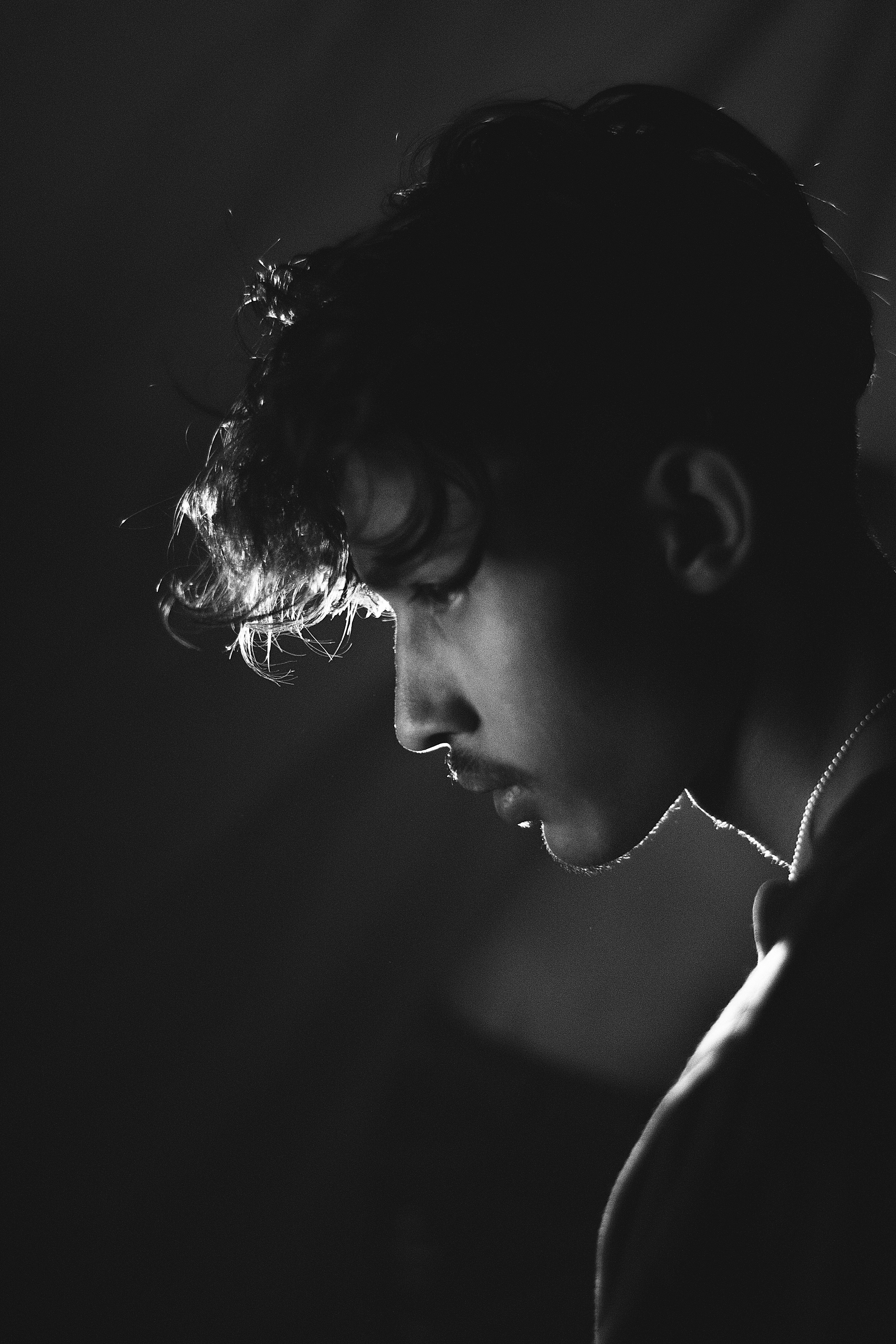 Artistic black and white portrait of a young man with dramatic lighting.