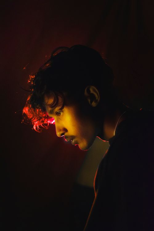 Free Dramatic portrait of a young man in moody lighting, capturing an artistic and introspective moment. Stock Photo