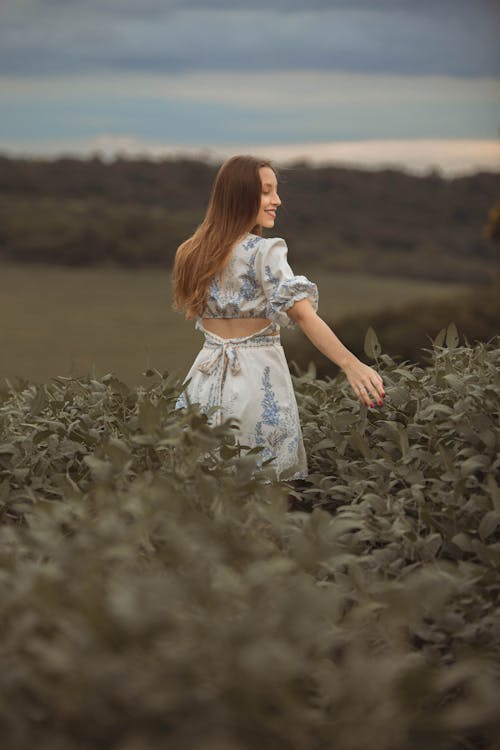 Smiling Woman in a Dress Walking Through the Crops