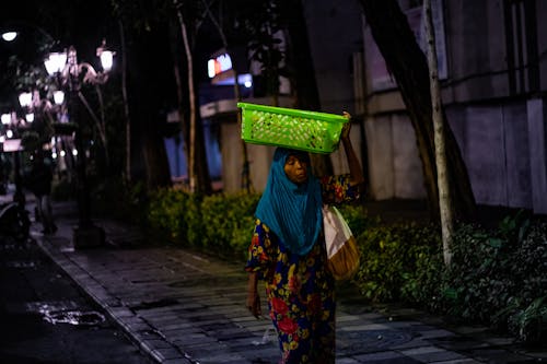 Woman Carrying Green Basket On Her Head