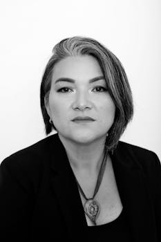 Black and white portrait of a woman in a formal pose, exuding elegance and confidence.