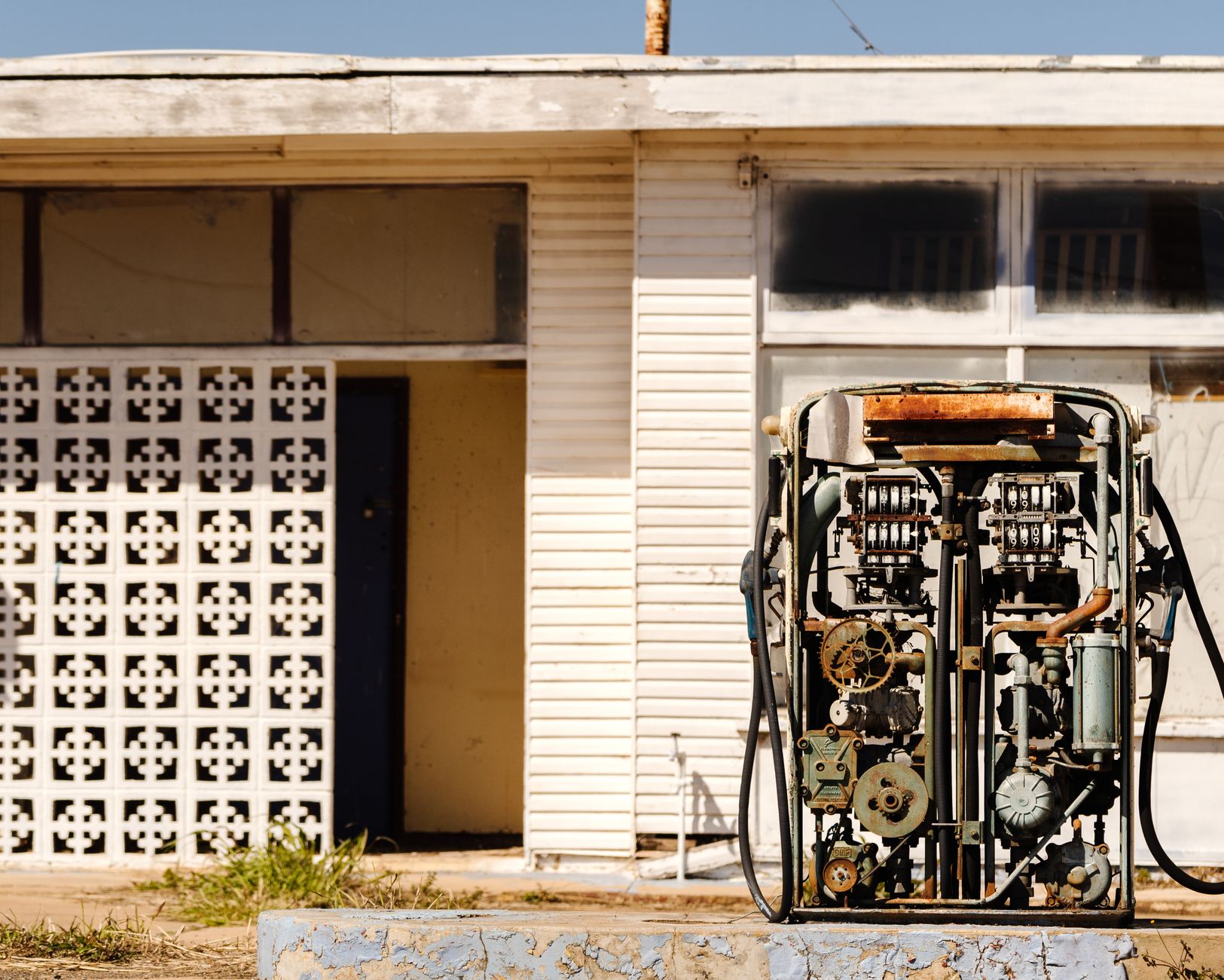 An old rusty gas pump in front of an abandoned building in Maryvale, Australia.