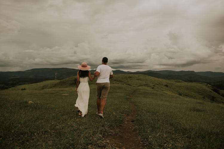 Couple Walking On Green Hill