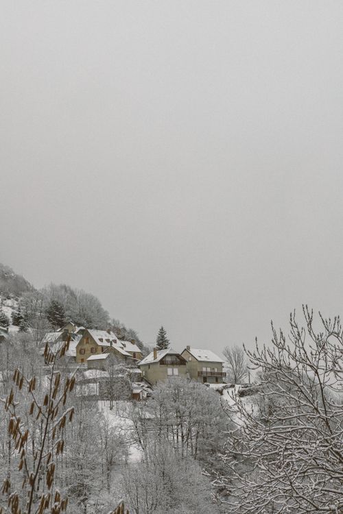 Free Peaceful snowy village nestled in a quiet hillside, evoking calm and tranquility. Stock Photo