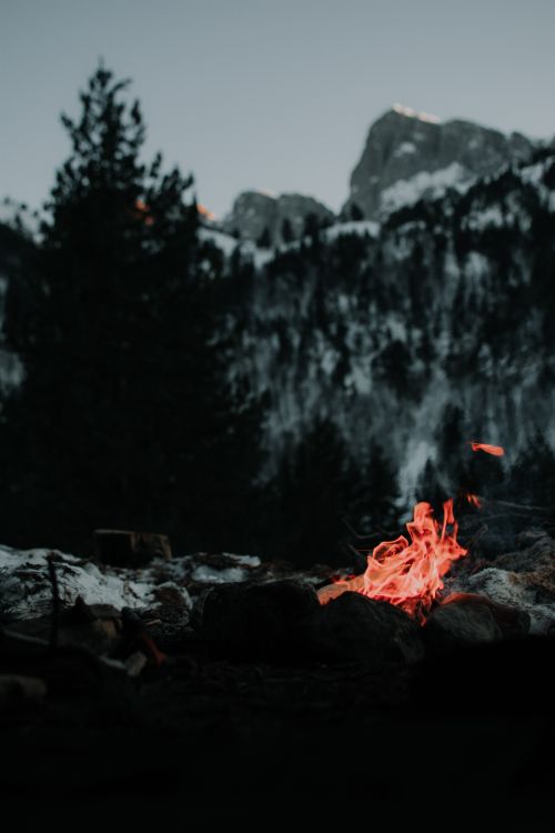 Free Tranquil campfire with snow-capped mountains in Greece during twilight. Stock Photo