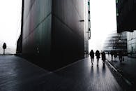 一个剪影戏剧性的人走在伦敦现代都市的街道上，身旁是醒目的建筑