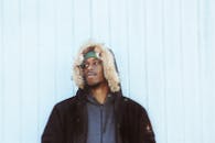 寒冷的日子里，一名身着毛皮衬里连帽夹克的男子在户外拍摄的肖像，传递出时尚的冬季氛围