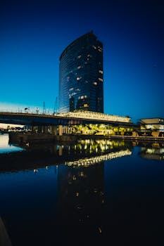 黄昏的蓝天下，一座引人注目的现代摩天大楼倒映在伦敦的河中