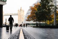 伦敦塔桥附近，一名带着行李的旅客剪影出现在秋天