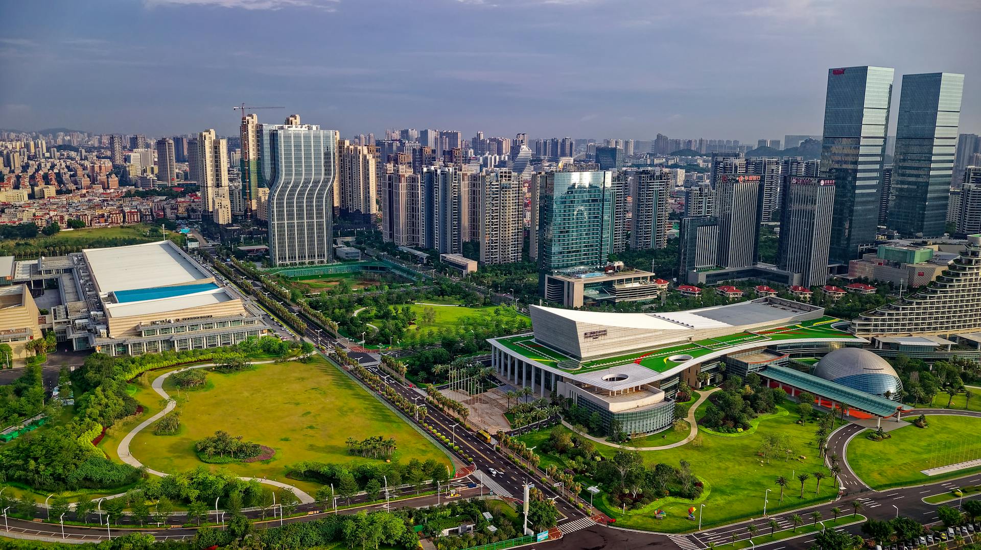 Aerial view of modern skyline in Xiamen City, showcasing lush green parks and innovative architecture.