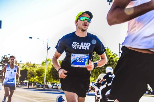 Free Dynamic capture of marathon runners competing outdoors on a sunny day. Stock Photo