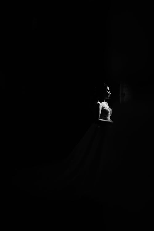 Woman in Dress Standing in the Dark