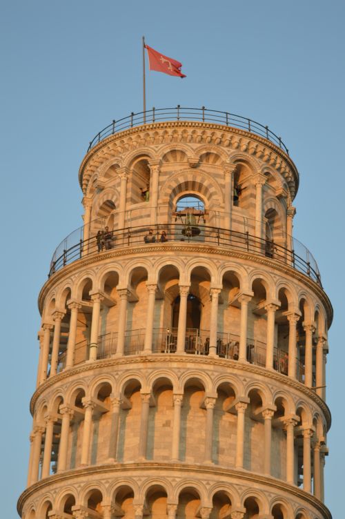Free Detailed view of the Leaning Tower of Pisa with a flag at sunset. Stock Photo
