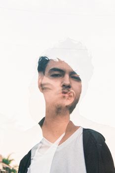 Creative double exposure portrait capturing a man's reflection and expression in an artistic style.