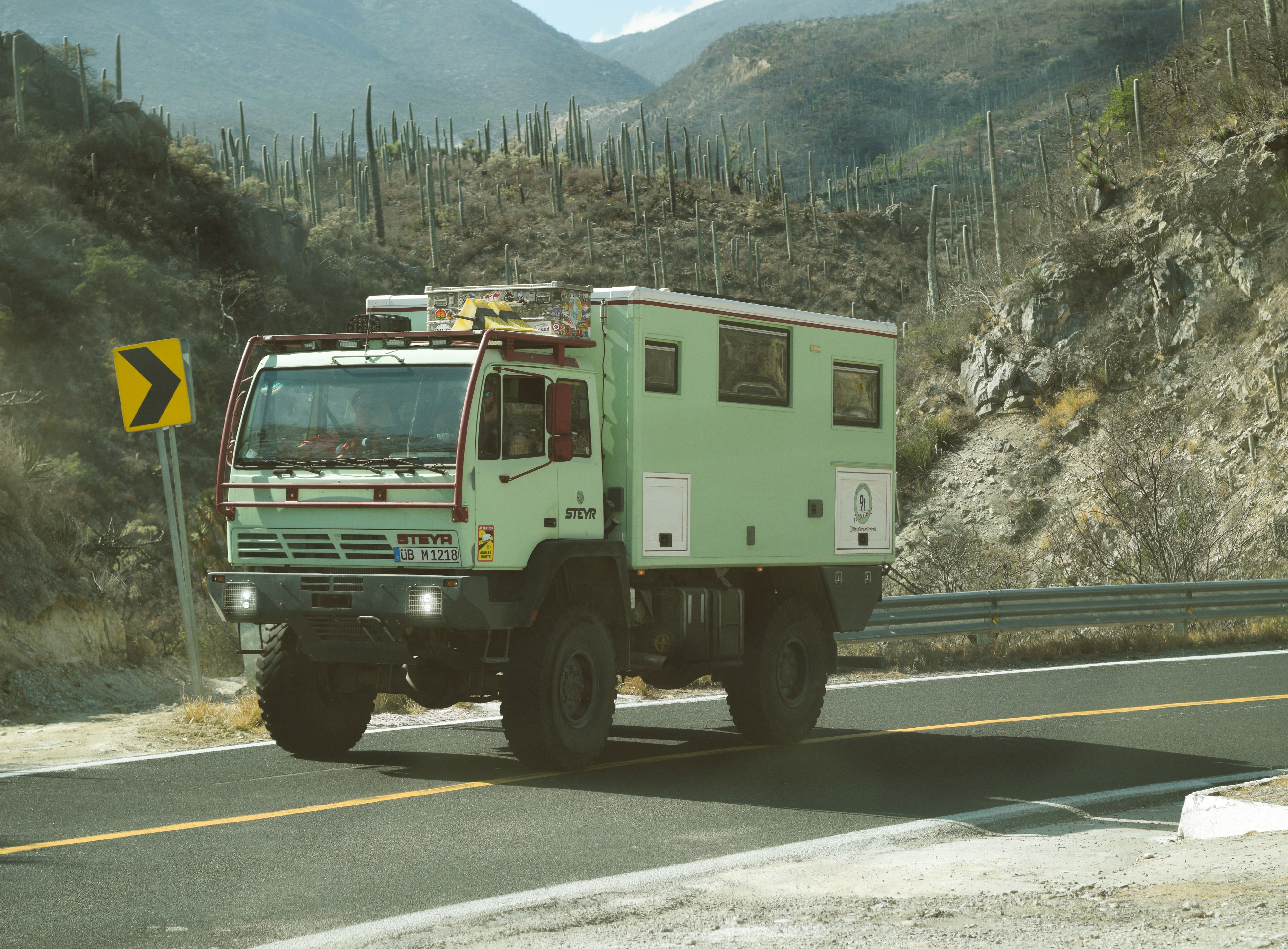 A rugged Steyr truck travels on a deserted mountain road
