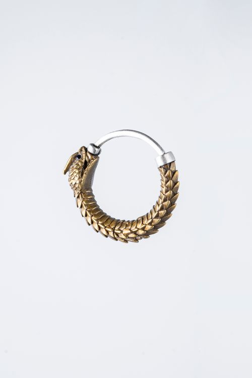 Free Close-up of a golden snake-shaped earring with intricate details on a white background. Stock Photo