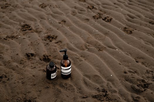 Eco-friendly skincare bottles on a natural sandy beach setting, emphasizing sustainability.