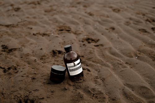 Bottle and Box on Sand