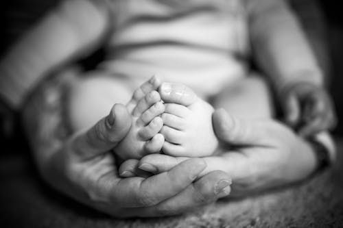 Black and White Photo of a Newborn Baby in Hands