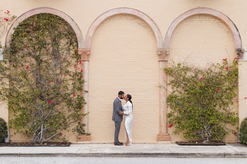 Couple Kissing in Front of an Arched Wall