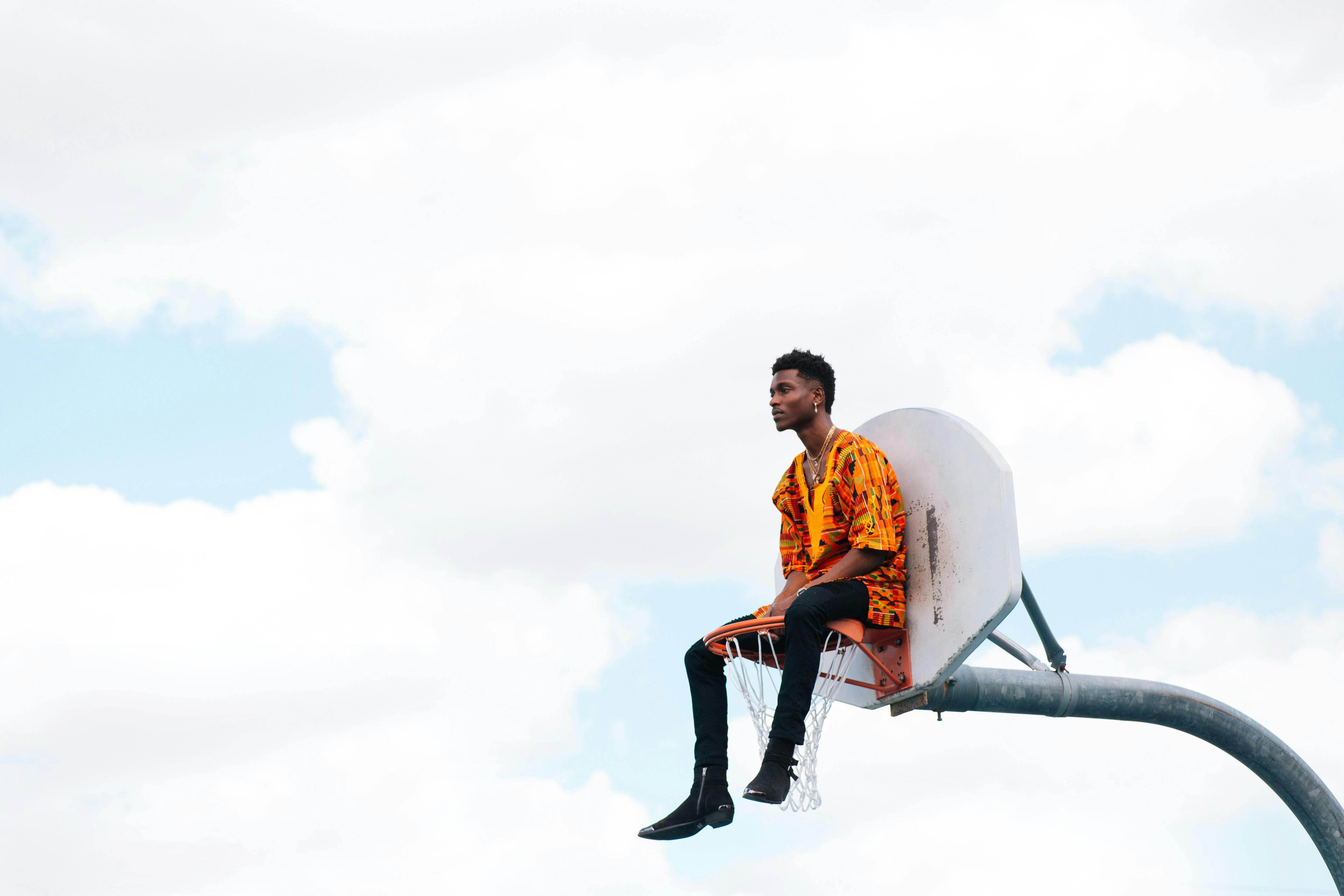 man sitting in a basketball hoop