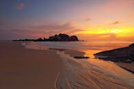 岩石海岸上日出宁静，海浪温和，天空色彩鲜艳