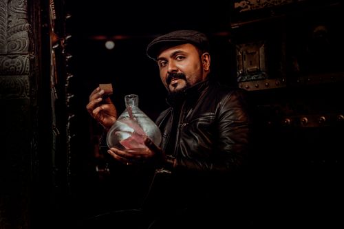Free Portrait of a man in leather with a glass jar, exuding dark and moody vibes. Stock Photo