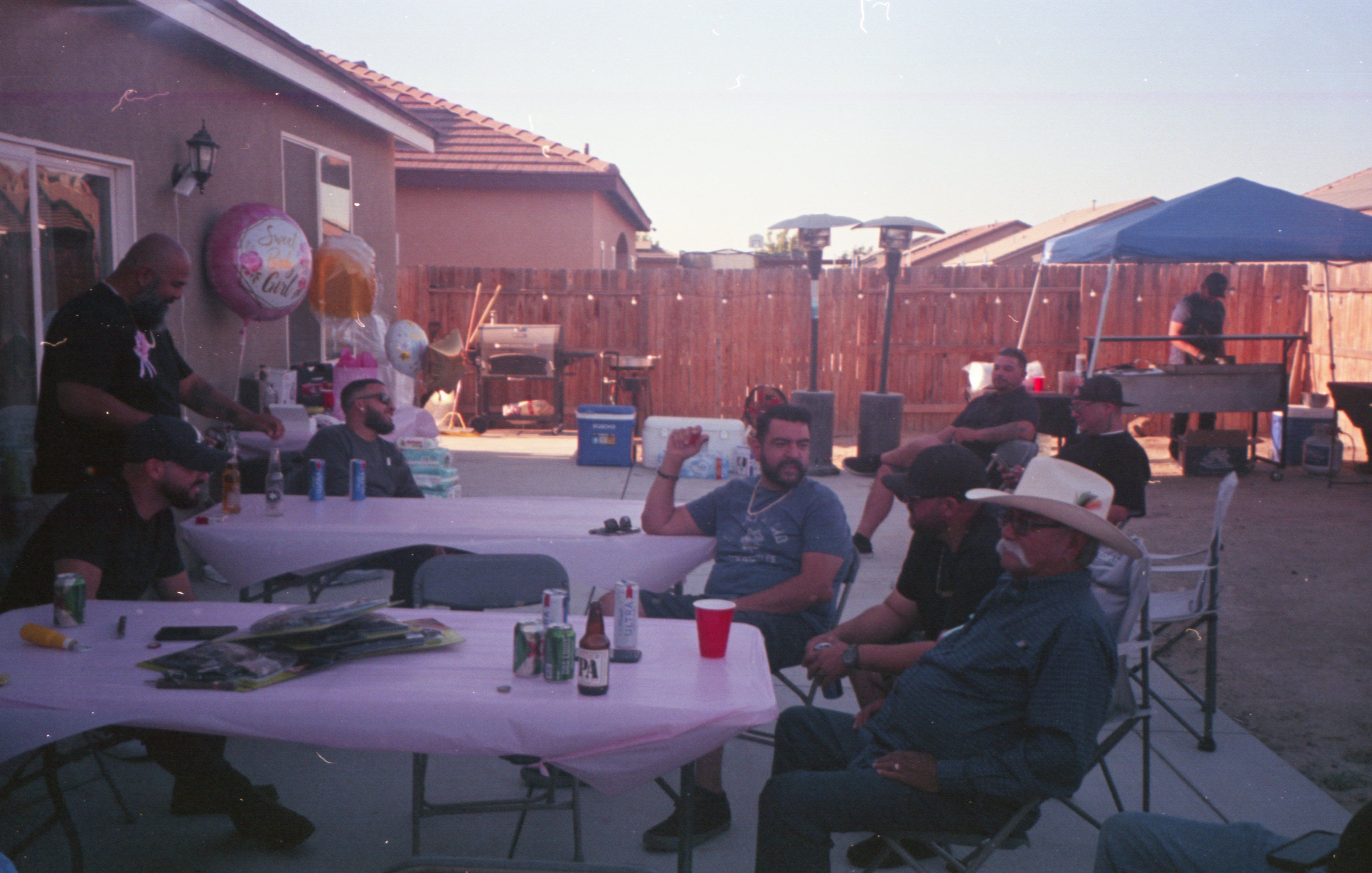 Mates talking through a low-key bucks party plan in a backyard setting