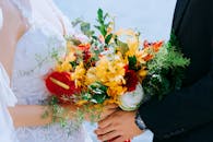 越南胡志明市一对新人的婚礼特写，他们手持充满活力的花束