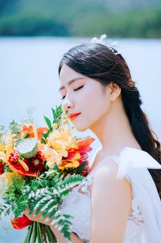 Portrait of a bride with a colorful bouquet in Đà Lạt, Vietnam, capturing natural beauty.