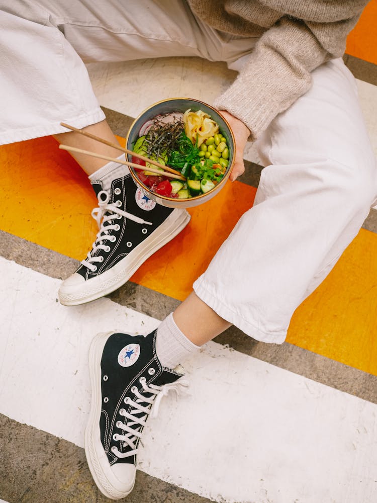 Close Up Of Woman Sitting With Bowl Of Food