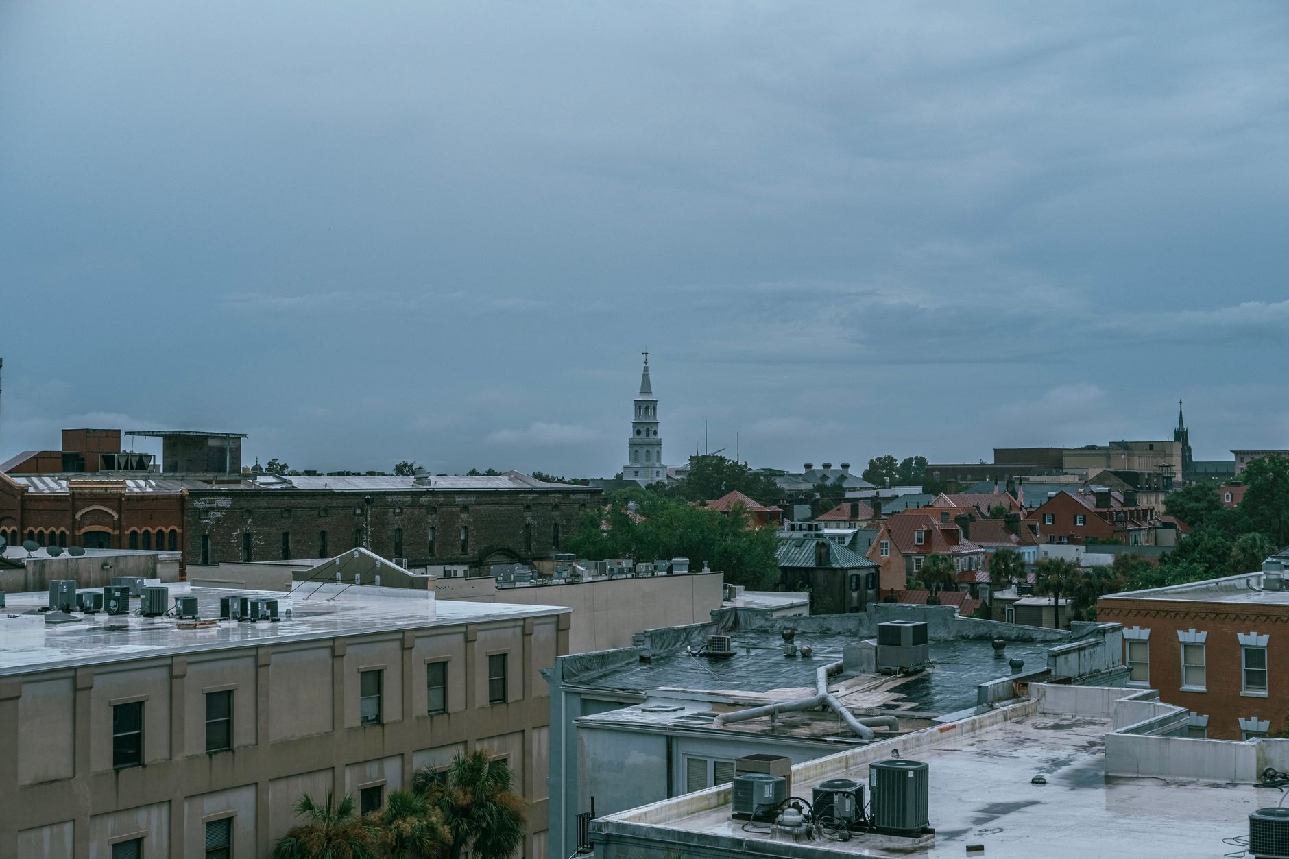 Aerial cityscape of Charleston, SC showcasing historic architecture under a cloudy sky.