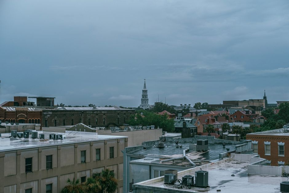 Aerial cityscape of Charleston, SC showcasing historic architecture under a cloudy sky.