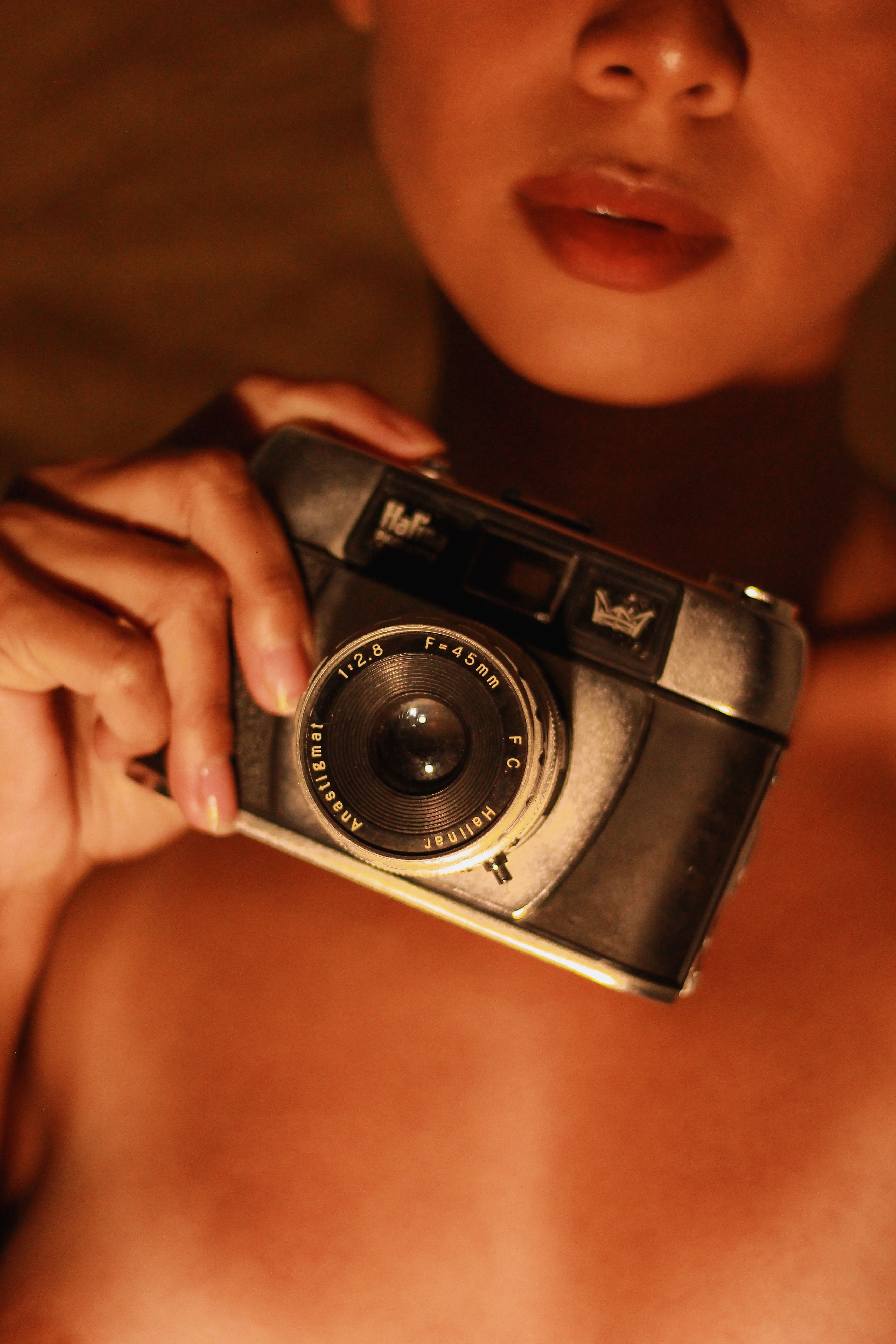 A close-up of a woman holding a vintage camera, capturing an intimate moment in São Paulo.