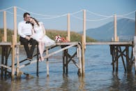 一对幸福的情侣坐在湖边的木码头上，享受着团聚的时光