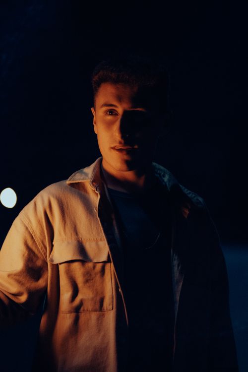 Free A dramatic night portrait of a young man illuminated against a dark background in Fethiye, Türkiye. Stock Photo