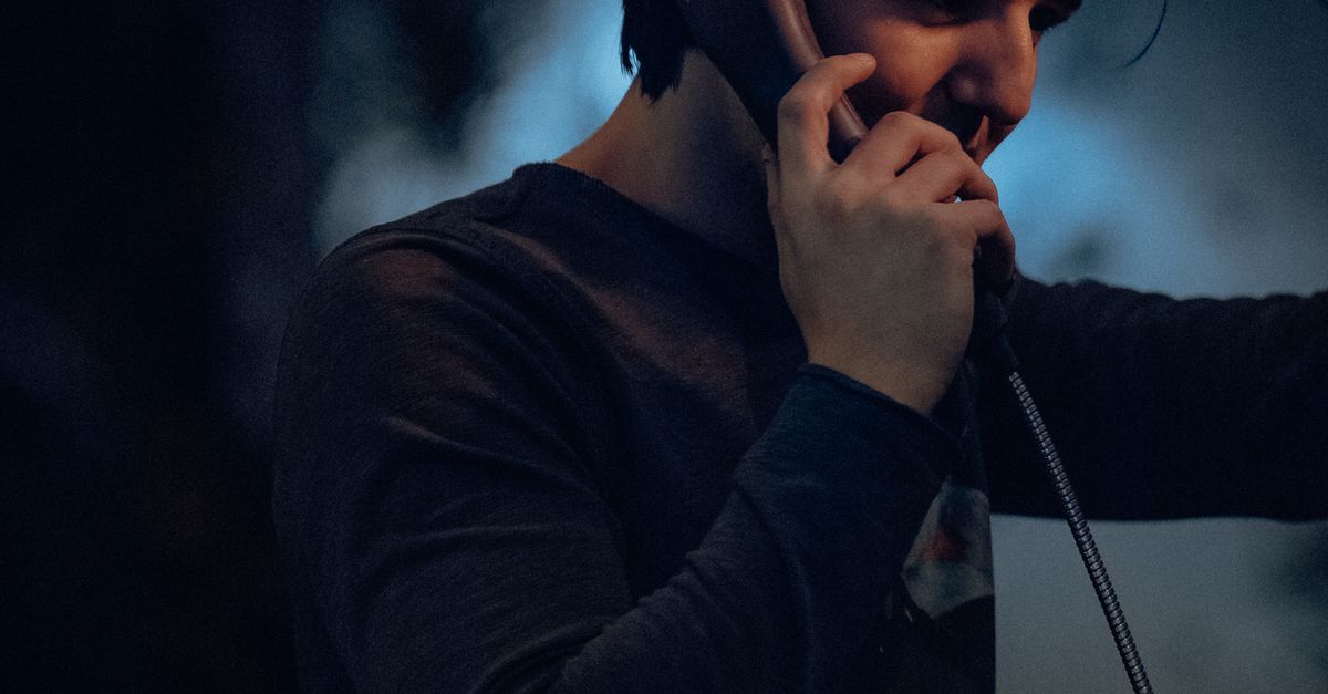 Young Man Using a Payphone · Free Stock Photo