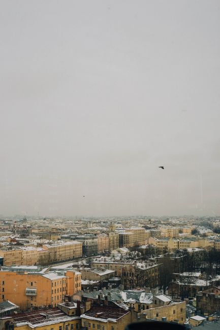 Aerial view of a snow-covered cityscape during winter, showcasing historic urban architecture.