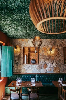 Charming bistro interior with stone walls, green sofa, and wooden elements in Tiradentes, Brazil.