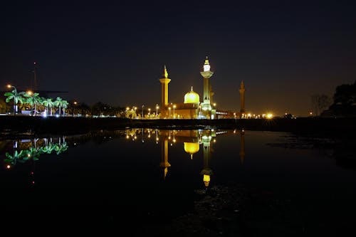 бесплатная Отражение желтой высотной башни в ночное время Стоковое фото