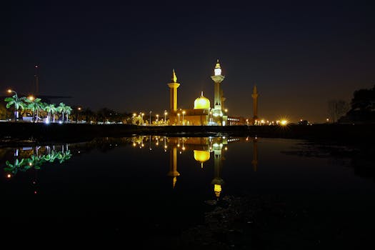 Reflection of Yellow High Rise Tower during Night Time