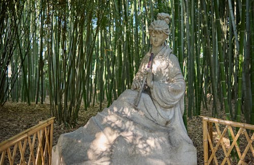 Sculpture of a Woman with a Flute in a Bamboo Forest 