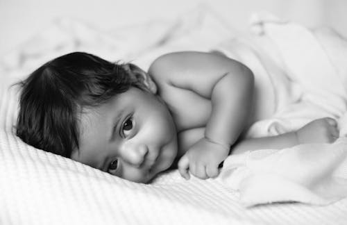 Free Black and White Portrait of Boy in Bed Stock Photo